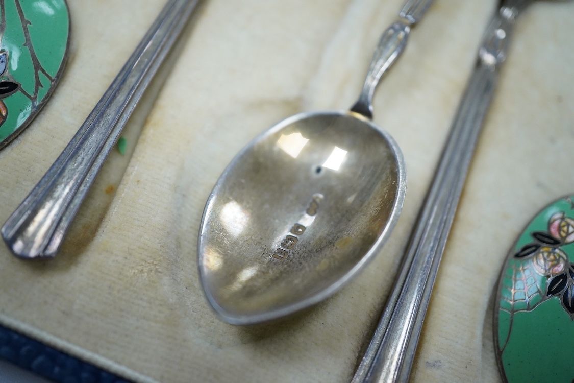 A cased set of six George V Art Deco silver and enamel coffee spoons, By Turner & Simpson, Birmingham, 1933, 98mm, the bowl backs decorated with a rose bush with spider's web.
